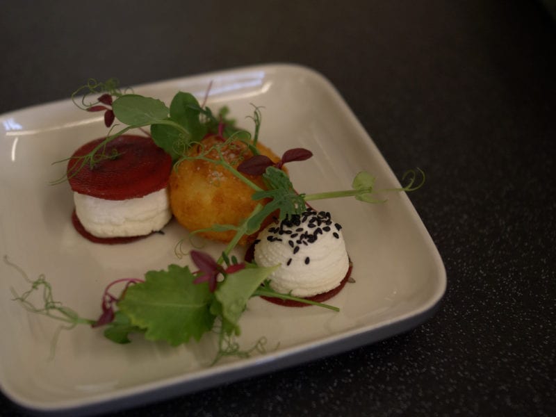 a picture of beetroot and cheese curd with a deep fried ball and salad garnish