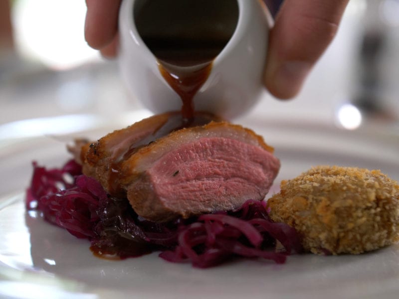 a picture of a plate of cooked duck and red cabbage