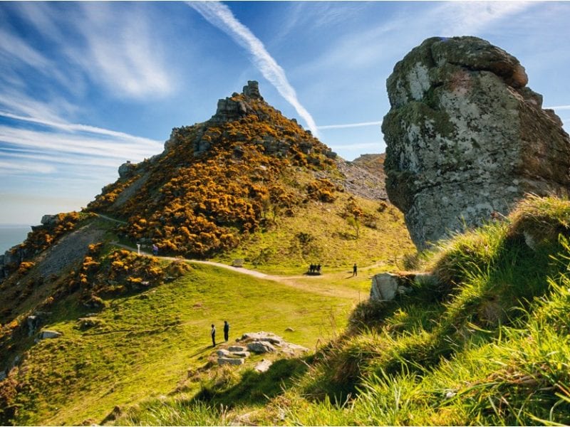 a picture of large cliffs and grass covered rocks, Valley of Rocks