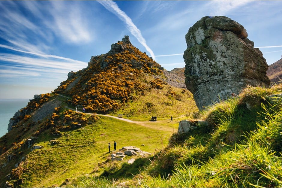 a picture of large cliffs and grass covered rocks, Valley of Rocks