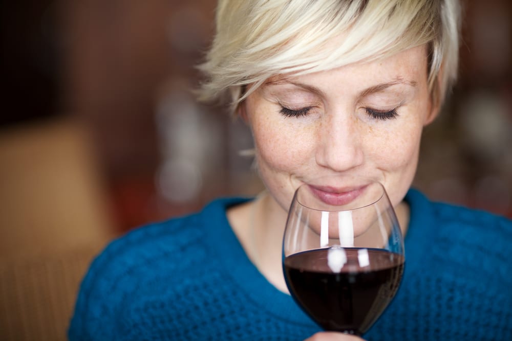 Lady smelling a glass of red wine